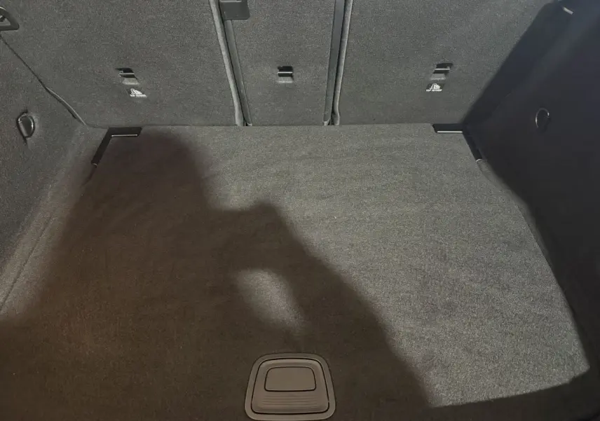 Vue plongeante sur le coffre spacieux et tapissé de moquette noire d'une Mercedes Classe A A 200 AMG Line 2021.