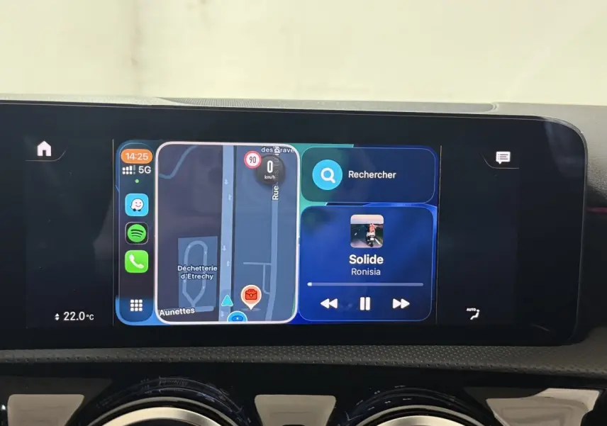 Écran tactile central de la Mercedes Classe A 200 AMG Line 2021 affichant navigation et musique, vue intérieure frontale.