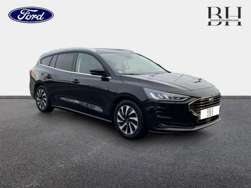 Ford Focus SW 2024 noir Agate métallisé, vue 3/4 avant droit, calandre chromée et jantes alliage visibles.