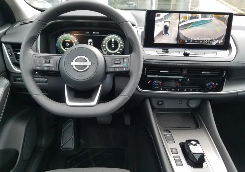 Vue intérieure avant du Nissan Qashqai noir 2025, avec volant multifonction et écran tactile affichant la caméra 360°.