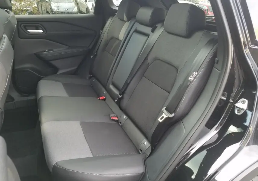 Vue intérieure côté droit sur la banquette arrière noire et grise du Nissan Qashqai 2025 avec porte ouverte.