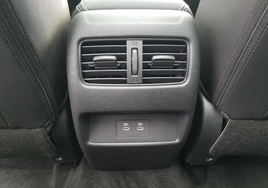 Vue rapprochée de la console arrière noire du Nissan Qashqai 2025 avec deux bouches d’aération et ports USB-C.