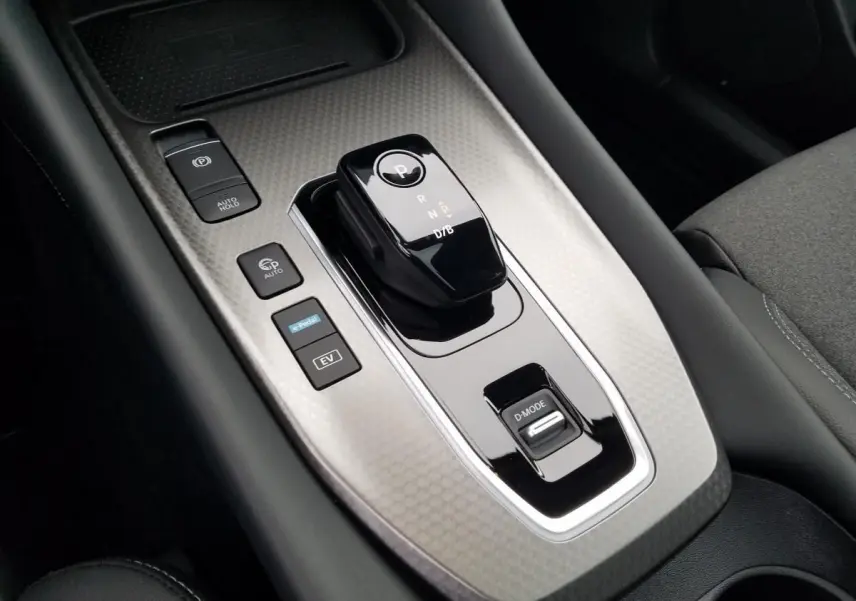 Gros plan sur la console centrale du Nissan Qashqai 1.5 E-POWER 2025 avec levier de boîte auto et boutons de contrôle.