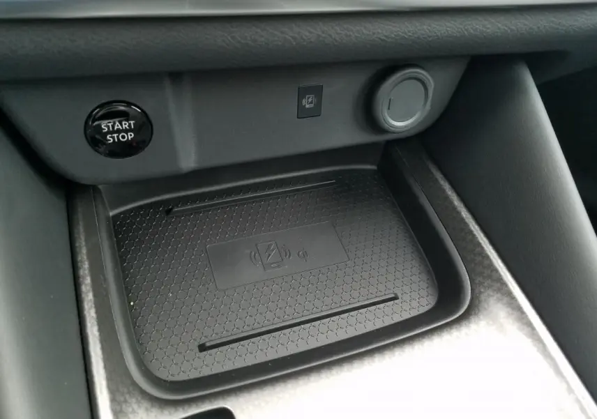 Gros plan intérieur sur le chargeur à induction noir et le bouton Start/Stop du Nissan Qashqai 1.5 E-POWER 2025.