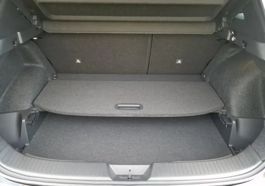 Coffre ouvert vu de l'arrière du Nissan Qashqai noir 2025, montrant la plage arrière et le tapis de coffre.