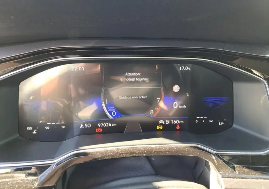 Tableau de bord numérique de Volkswagen Polo gris 2022, affichant vitesse, température et alertes moteur.