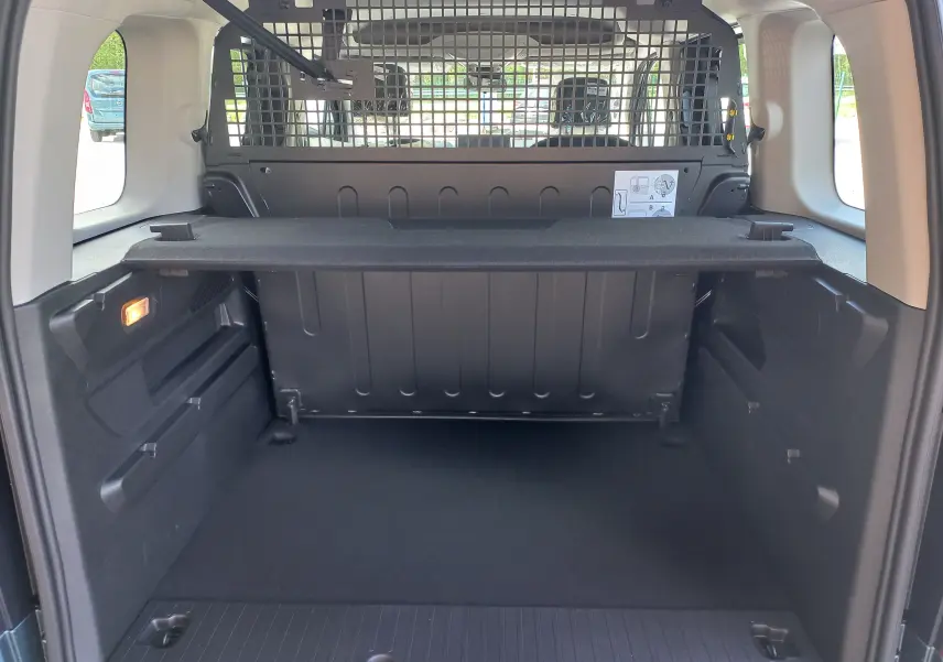 Vue intérieure du coffre de l'Opel Combo Life bleu Kiama 2025, avec séparation grillagée et tablette de rangement.