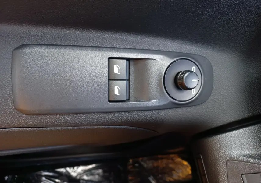 Gros plan sur les commandes de réglage des rétroviseurs et des vitres côté conducteur de l’Opel Combo Life bleu Kiama 2025.