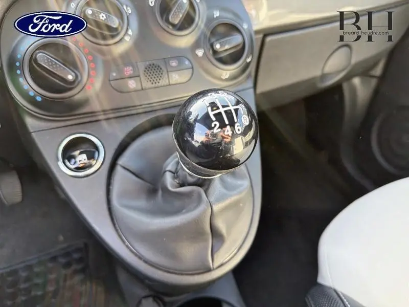 Le levier de vitesse manuel noir en gros plan dans l'habitacle d'une FIAT 500 Electroclash Grey Métal, vue côté passager.