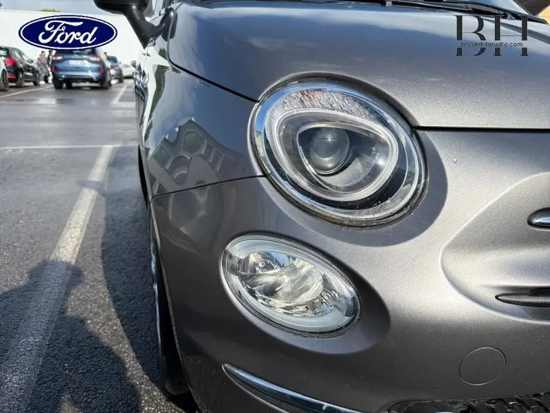 Gros plan sur l'avant droit de la FIAT 500 Electroclash Grey Métal, mettant en valeur ses phares ronds distinctifs.