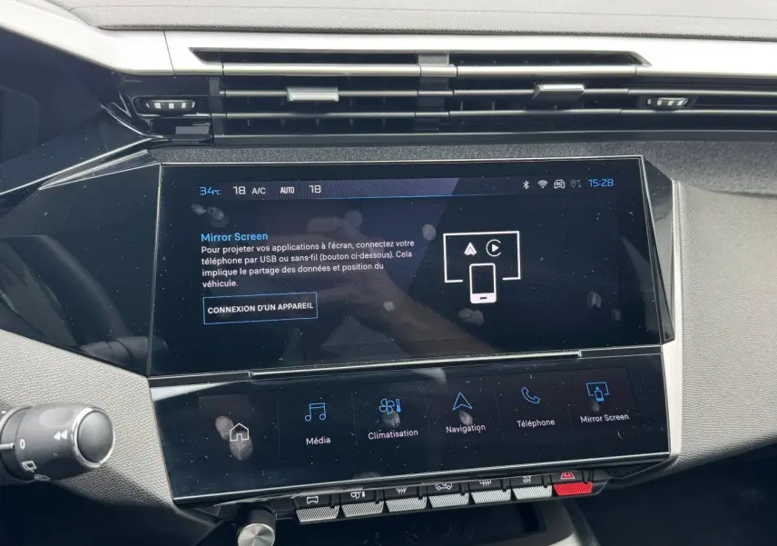 Vue rapprochée de l’écran tactile central du tableau de bord de la Peugeot 308 1.2 Hybrid 2025, affichant le menu Mirror Screen.