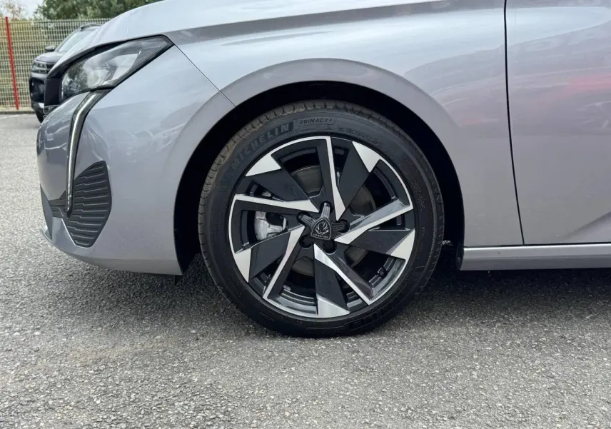 Gros plan sur la roue avant gauche d’une Peugeot 308 gris Artense 2025 avec jante alu au design moderne.