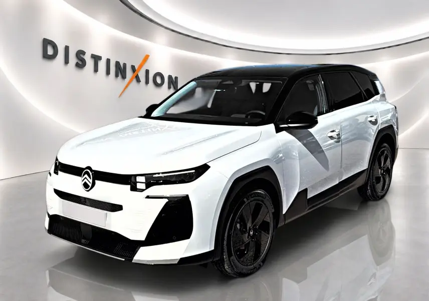 Vue 3/4 avant droit du Citroën C5 Aircross blanc à toit noir avec jantes alliage noires dans un showroom.