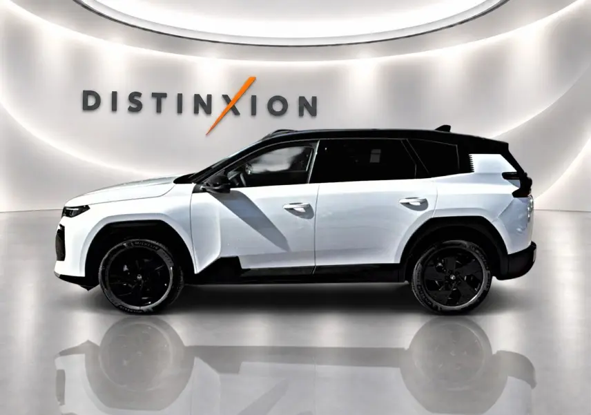 Profil droit du Citroën C5 Aircross blanc à toit noir avec jantes alliage noires dans un showroom lumineux.
