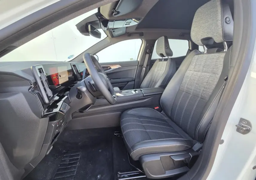 Vue intérieure côté conducteur du Renault Austral blanc nacré, sièges tissu et cuir, toit panoramique noir étoilé.