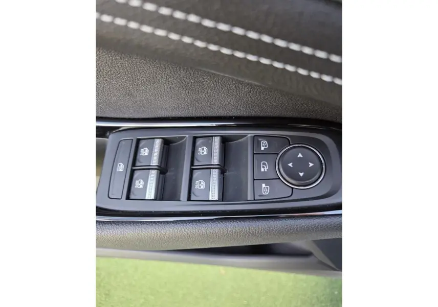 Gros plan sur les commandes des vitres et rétroviseurs côté gauche du Renault Austral E-Tech blanc nacré.