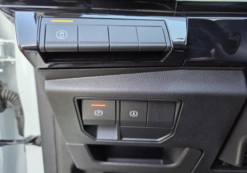 Gros plan sur les commandes de frein de parking et arrêt auto du Renault Austral E-Tech blanc nacré, côté gauche conducteur.