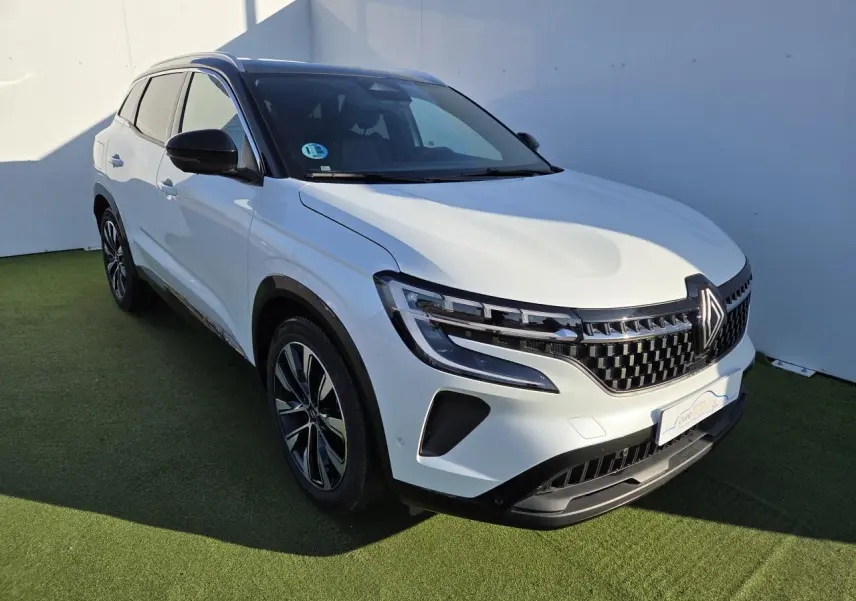 Renault Austral blanc nacré avec toit noir, vue 3/4 avant droit, jantes alliage noires et calandre distinctive.