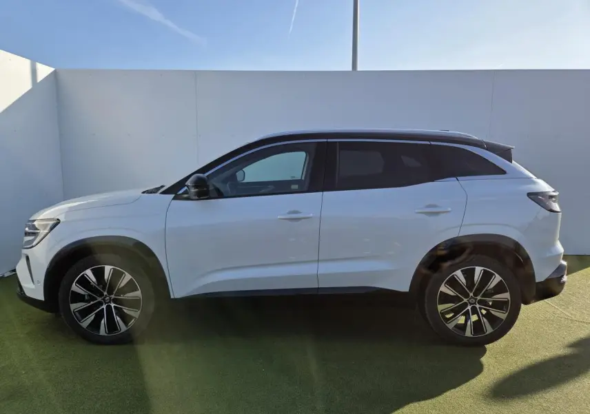 Profil droit du Renault Austral blanc nacré avec toit noir étoilé et jantes alliage noires diamantées.