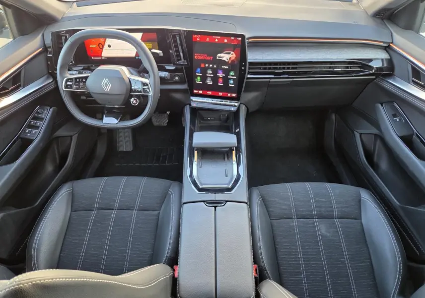 Vue intérieure avant de la Renault Austral E-Tech, tableau de bord moderne avec écran tactile vertical et sièges noirs.