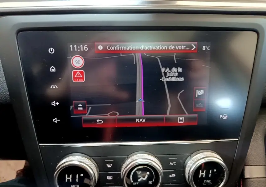 Gros plan sur l'écran tactile central du tableau de bord du Renault Kadjar rouge, affichant la navigation GPS.