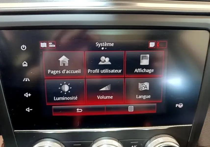 Écran tactile central du Renault Kadjar rouge, affichant le menu système avec options luminosité, volume et langue.