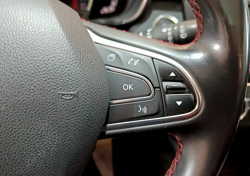 Gros plan sur le côté droit du volant cuir noir avec surpiqûres rouges du Renault Kadjar 2019.