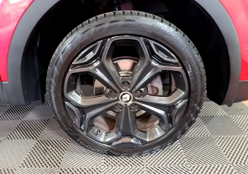 Gros plan sur la roue avant droite avec jante noire brillante du Renault Kadjar rouge SL Black Edition 2019.