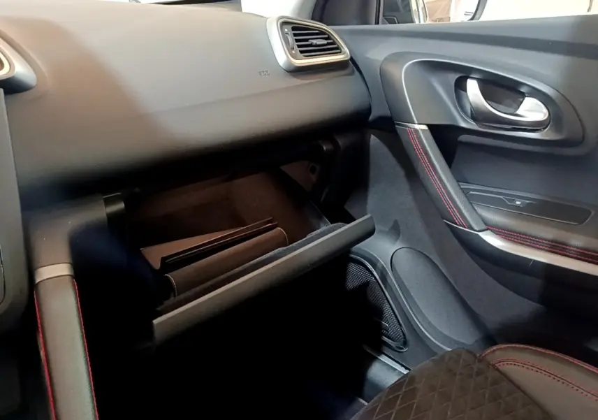 Intérieur côté passager du Renault Kadjar rouge 2019, avec boîte à gants ouverte et surpiqûres rouges sur la porte.