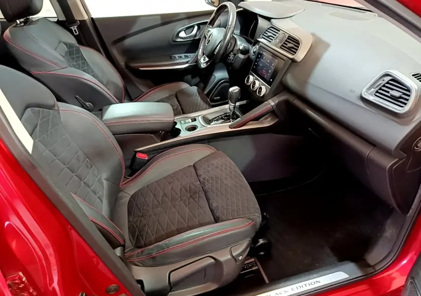 Vue intérieure côté conducteur du Renault Kadjar SL Black Edition rouge, sièges noirs avec surpiqûres rouges et tableau de bord moderne.