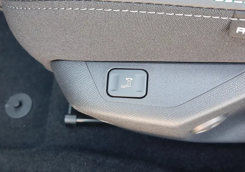 Gros plan sur le bouton de réglage électrique du siège avant dans l'habitacle noir de la Peugeot 308 Bleu Obsession.