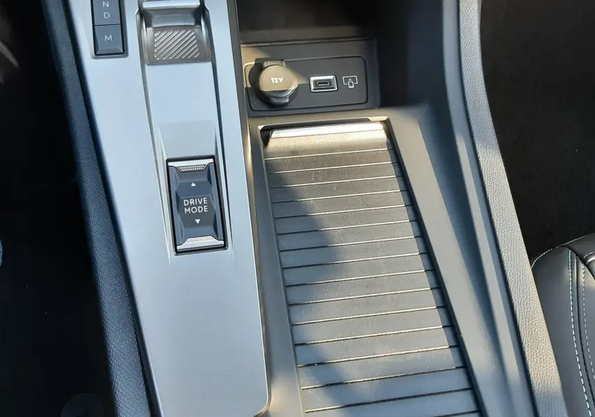Vue rapprochée de la console centrale noire de la Peugeot 308 2025 avec sélecteur de boîte auto et prise 12V visible.