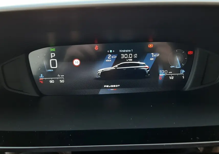 Affichage numérique du tableau de bord de la Peugeot 308 Bleu Obsession, montrant la silhouette du véhicule et les informations de conduite.
