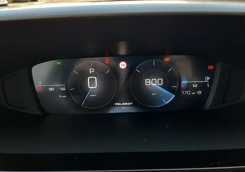 Vue rapprochée du tableau de bord numérique de la Peugeot 308 Bleu Obsession, affichant vitesse, régime et autonomie.