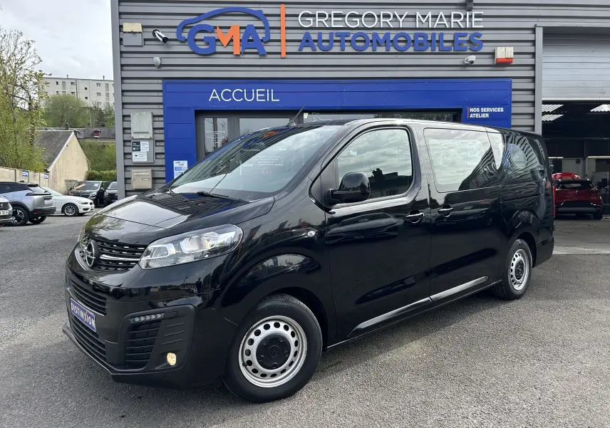 Opel Vivaro Combi noir en 3/4 avant droit, garé devant un garage Gregory Marie Automobiles.