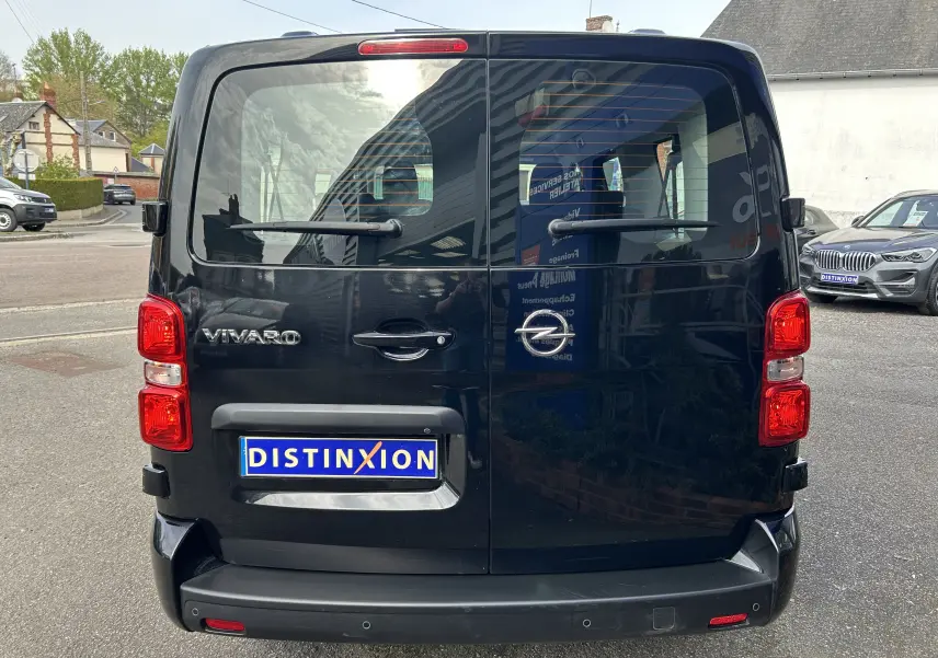 Vue arrière d'un Opel Vivaro Combi noir avec portes battantes et feux rouges bien visibles, immatriculé Distinxion.