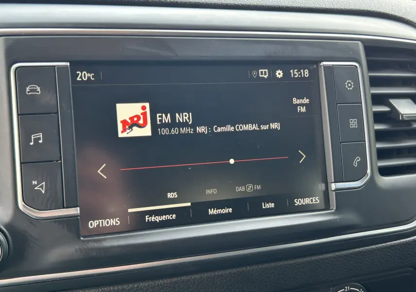 Écran tactile central de l’Opel Vivaro Combi noir affichant la radio FM NRJ à 15h18.