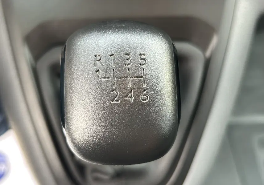 Gros plan sur le levier de vitesses manuel noir de l’Opel Vivaro Combi, montrant la grille des 6 rapports et la marche arrière.