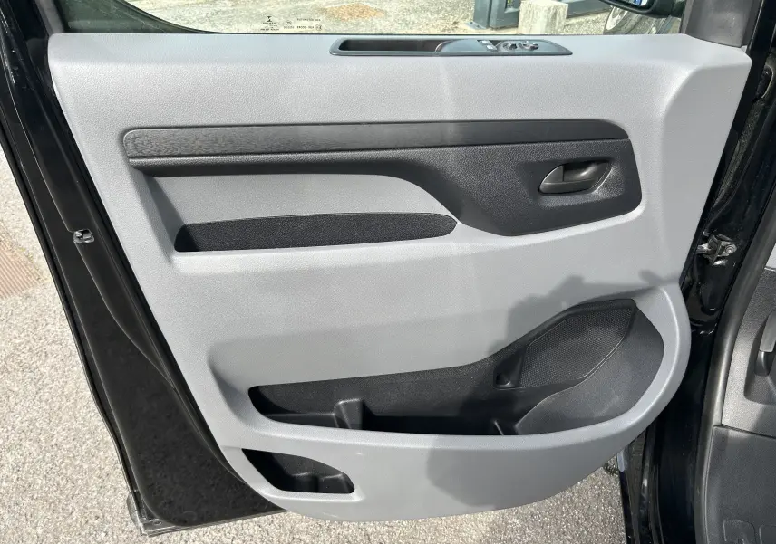 Vue rapprochée de la porte avant gauche noire de l’Opel Vivaro Combi 2022, avec panneau intérieur gris et noir.