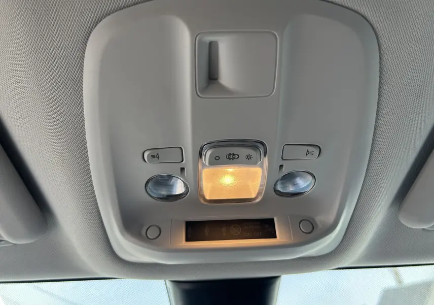 Plafonnier intérieur avec éclairage central allumé et commandes de lumière dans un Opel Vivaro Combi noir, vue de dessous.