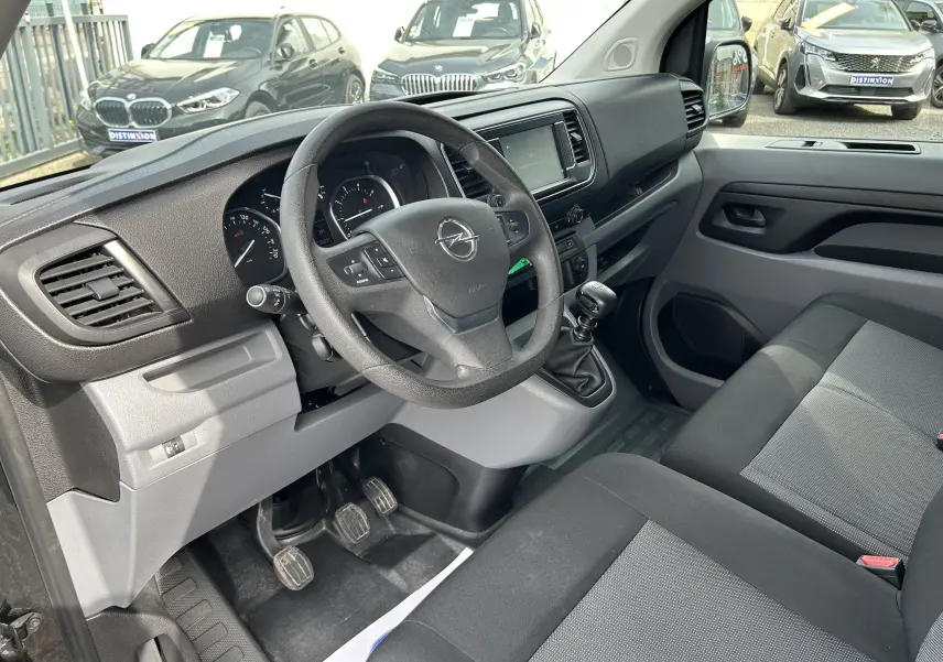 Vue intérieure côté conducteur de l'Opel Vivaro Combi noir 2022, volant multifonction et boîte manuelle visible.