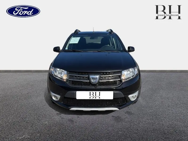 Dacia Sandero Stepway noir nacré vue de face avec barres de toit et boucliers couleur carrosserie.