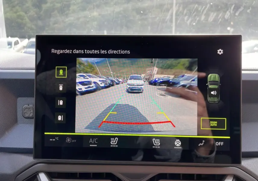 Écran de caméra multiview montrant la vue arrière d’un Dacia Duster vert cèdre en stationnement.
