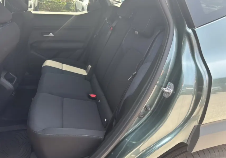 Vue côté droit sur la banquette arrière noire du Dacia Duster 2025 vert cèdre avec porte ouverte.