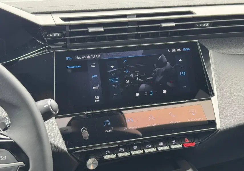 Vue rapprochée de l’écran tactile central et du volant noir dans l’habitacle moderne de la Peugeot 308 2025.