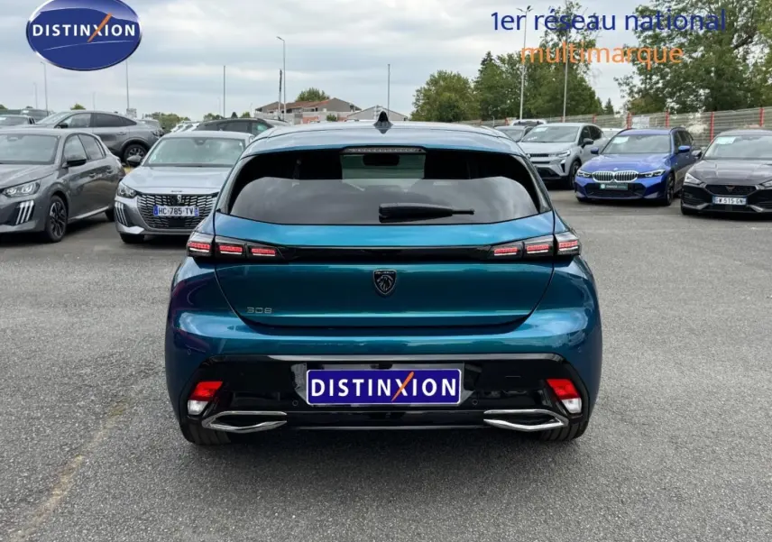 Vue arrière d'une Peugeot 308 bleu Obsession 2025, avec feux arrière LED et double sortie d'échappement chromée.