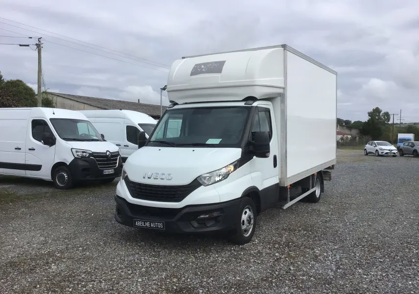 Camion Iveco Daily Chassis Cabine blanc vu en 3/4 avant droit avec caisse fermée et hayon arrière sur parking.