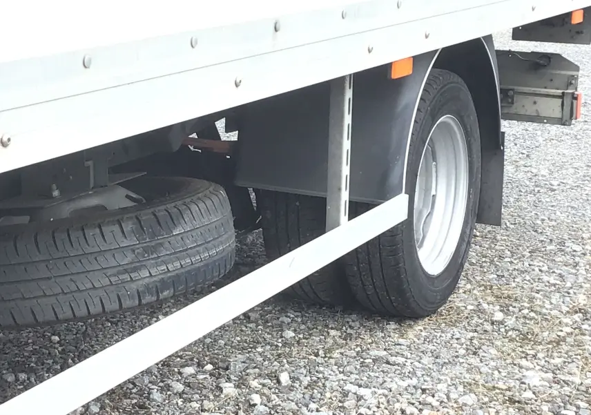 Gros plan sur la roue arrière droite du camion blanc Iveco Daily Chassis Cabine 35C16 avec caisse 20m3 et hayon.
