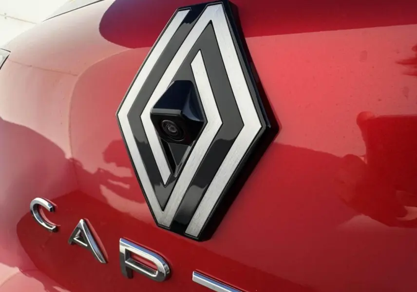Gros plan sur le logo Renault rouge flamme avec caméra intégrée sur le hayon arrière du Captur II.