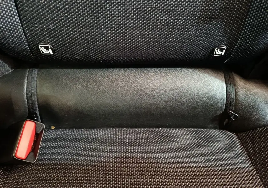 Détail de la banquette arrière noire du Renault Captur 2024 avec fixation Isofix et boucle de ceinture rouge visible.